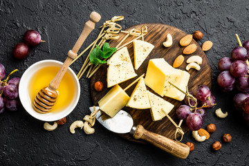 Cheese with grape and nuts on wooden board