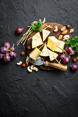 Cheese with grape and nuts on wooden board