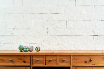 Christmas decoration with beautiful colorful baubles on the old shelf on the background of a white brick wall