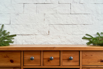 Christmas decoration with blank space with twigs of spruce on an old shelf on the background of a white brick wall
