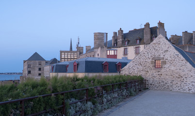 View at sunset from the wall of the old city with granite buildings of Saint-Malo in Brittany,...