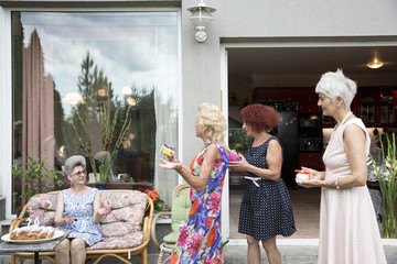 Three mature women walking towards their celebrated friend