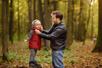 Fototapeta premium Little boy with his father during stroll in the forest