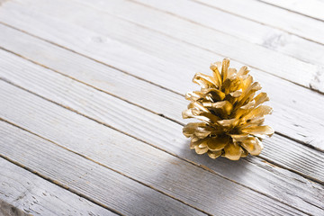 Naklejka premium golden pine cone Christmas decoration on old rustic wooden table background