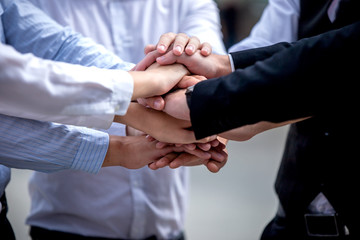 Closeup on hands. Colleague putting their hands on top of each other symbolizing unity and teamwork while doing activity outdoor. People joining hand together as a business goal achievement