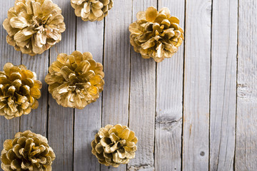 golden pine cones Christmas decoration on old rustic wooden table background
