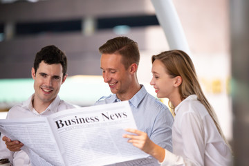 Business people reading newspaper outdoor