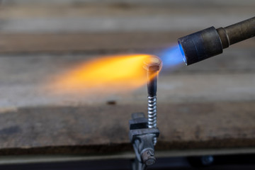 Metal heating with a gas burner in a home workshop. Tempering steel with flames.