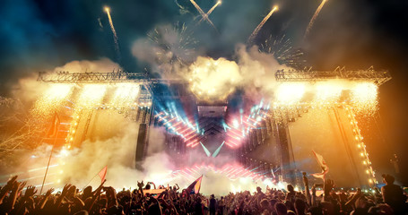Crowd at concert and blurred stage lights with fireworks