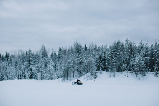 Snowmobile in snowy landscape with fir forest