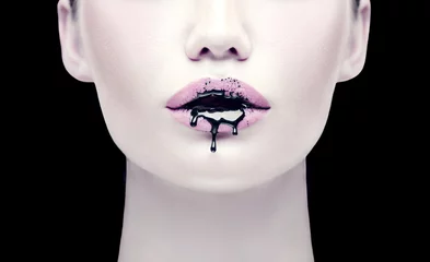 Poster Im Rahmen Halloween-Party-Make-up, gotischer Stil. Schwarze Farbe tropft von den Lippen des schönen Modellmädchens. Schönheitsfrauengesicht lokalisiert auf schwarzem Hintergrund © Subbotina Anna