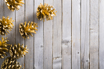 golden pine cones Christmas decoration on old rustic wooden table background