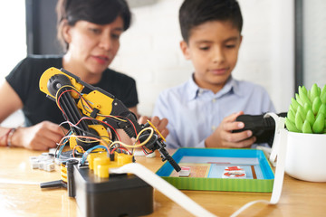 Adult woman and young boy doing a robot science experiment
