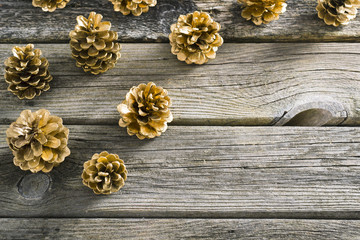 golden pine cones Christmas decoration on old wood table background