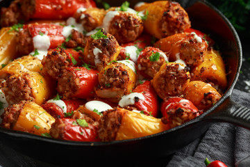 Sausage meat, mince and rice Stuffed sweet mini bell peppers baked in cast iron skillet, pan topped...
