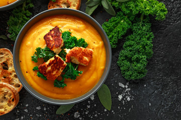 Baked butternut squash and carrot cream soup with steamed kale and fried halluomi