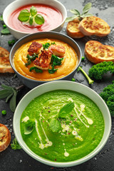 Variety of cream soup bowls: sweet pea and mint, tomato and basil and butternut squash with steamed kale and fried halluomi