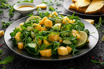 Pineapple Cucumber salad with wild green rocket, lime and olive oil. Healthy juicy food