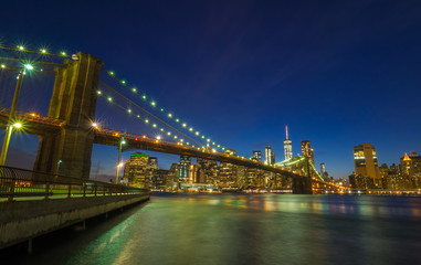 Brooklyn Bridge at night with water reflection, New York City Skyline, NY, USA