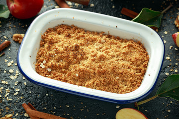 Traditional English apple crumble baked in vintage dish and served with cream