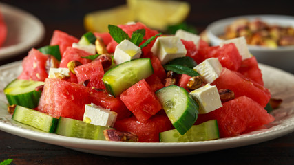 Healthy Watermelon, Cucumber Salad with Mint, pistachios nuts and feta cheese. rustic wooden background