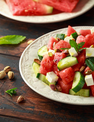 Healthy Watermelon, Cucumber Salad with Mint, pistachios nuts and feta cheese. rustic wooden background