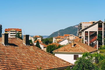 Typical roofs of Tivat on a sunny summer day. Houses surrounded by mountains
