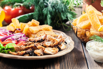 Greek gyros dish with french fries and vegetables