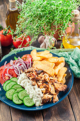 Greek gyros dish with french fries and vegetables