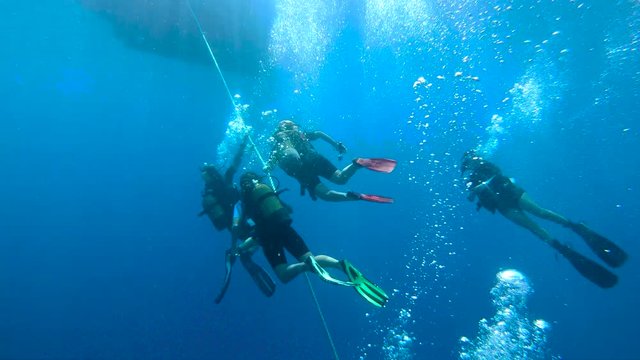 Group of scuba divers ascending on anchor line in Kas, Turkey