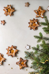 Obraz na płótnie Canvas Homemade Christmas star shape sugar caramel cookies with frosting and orange citrus jam over white marble background with fir branches. Flat lay, space. Sweet xmas or new year gift.