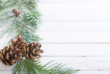 Christmas decoration background: pine and cypress cones with twigs on white wood table