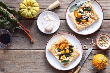 Pumpkin, chard, goat cheese and pine nuts puff pastry tarts. Overhead view