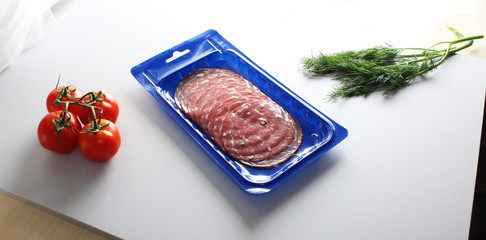 blue vacuum packing sausage cut on a light background