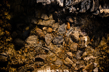 Stone beneath serene river water, river water waves brushing through the stones fresh water stream in mountain brook, close up