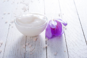 cosmetic cream and autumn crocus herbal flower on white wooden table