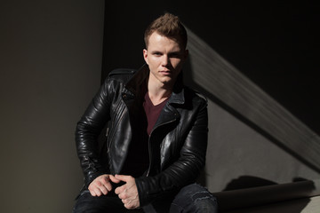 fashion portrait of a man in black fancy leather jacket