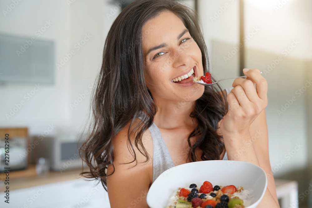 Wall mural Brunette woman having healthy breakfast at home