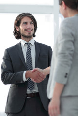 Friendly smiling business people  handshaking after pleasant tal