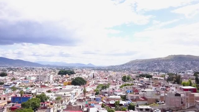 Descending aerial shot over Oaxaca City in Oaxaca, Mexico on a sunny day.