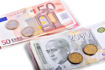 Serbian money and euro banknotes next to each other, isolated on white background