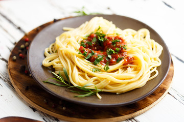 Plate with pasta with sauce ,tarragon, onion. Ingredients for cooking pasta.