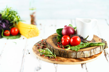 Cherry, tarragon, spaghetti, chili pepper, basil, spices Ingredients for cooking pasta. Food background on a white table