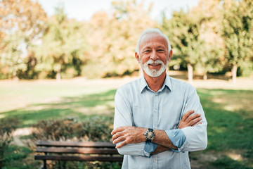 Portrait of a smiling older man in the park.