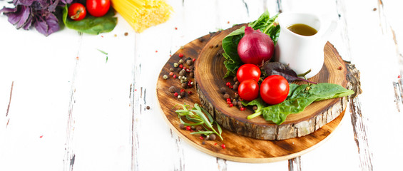 Cherry, tarragon, spaghetti, chili pepper, basil, spices Ingredients for cooking pasta. Food background on a white table