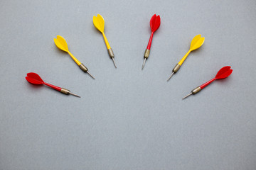 darts red and yellow on gray paper background