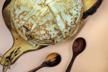 A plate with pancakes stands on a cutting board.