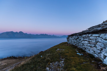 Colorful Early Morning Autumn Mountain Panorama View From Mt. Mohar In Nationalpark Hohe Tauern Carinthia To Schober Group and Grossglockner With Fog Down Above The Valley