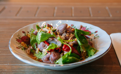 Thai food on dinner table, spicy beef salad in vintage caremic plate