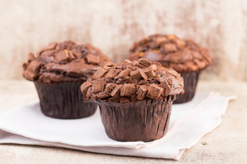 Homemade muffins with chocolate, vintage background.